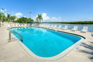 a swimming pool with chairs and a body of water at Little Harbor Resort #306 Tampa Bay FL Beach, Bayside, 2 Pools in Ruskin