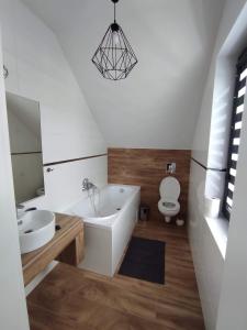 een badkamer met een bad, een wastafel en een toilet bij U Sadzy in Krajno Pierwsze