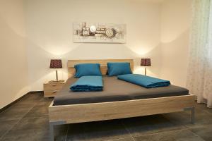 a bedroom with a large bed with blue pillows at Seeblick Susanne in Schiefling am See