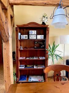 a room with a wooden book shelf with radios at Ferienwohnungen Jowatzky Altkötzschenbroda in Radebeul