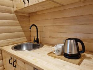 a kitchen counter with a sink and two mugs at Hedonist Village in Žabljak +148 photos