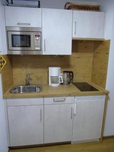 a small kitchen with a sink and a microwave at Landhaus Schanzblick in Bad Hindelang