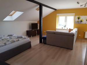 1 dormitorio con cama, sofá y ventana en Malinowa 36 Apartamenty, en Chojnice