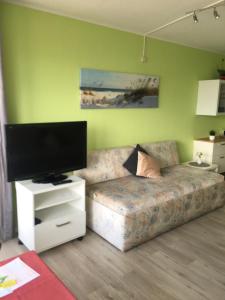 sala de estar con sofá y TV de pantalla plana en Laboe-Hafen, en Laboe