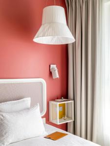 a bedroom with a white bed and white walls at OKKO Hotels Nice Aéroport in Nice
