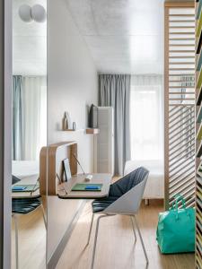 Habitación con escritorio, silla y cama. en OKKO Hotels Nice Aéroport en Niza