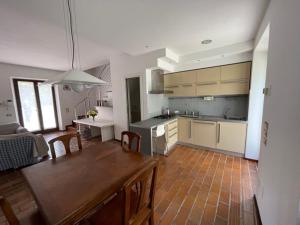 una cucina con tavolo in legno e una sala da pranzo di Villa Conero a Montacuto