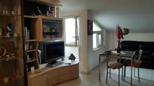 ein Wohnzimmer mit einem TV und einem Tisch mit einem Stuhl in der Unterkunft La Petite Maison in Quartu SantʼElena
