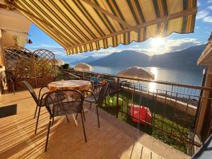 ブレンゾーネにあるAppartamenti Irideのテーブルと椅子付きのバルコニーから水辺の景色を望めます。