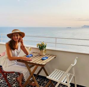 a woman sitting at a table on a cruise ship at Pezz Pezz in Praiano