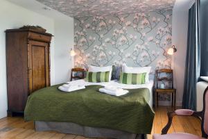 a bedroom with a bed with a floral wallpaper at Hotell Villa Vesta in Ronneby