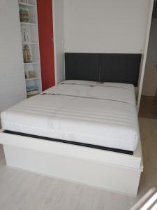 a bed in a room with a white mattress at Studio Raversijde with Sea View in Ostend