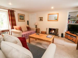 a living room with a couch and a fireplace at Springwells in Dunkeld