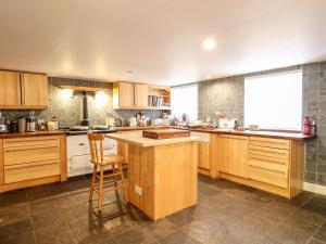 a large kitchen with wooden cabinets and a counter top at Springwells in Dunkeld