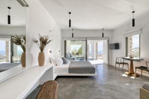 a bedroom with a bed and a living room at Tinos Dove Suites in Triandáros