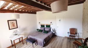 ein Schlafzimmer mit einem Bett, einem Tisch und einem Stuhl in der Unterkunft La Ferme Manoir Saint Barthélemy in Juaye-Mondaye