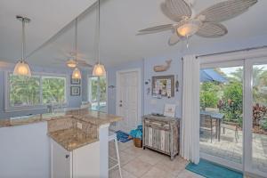 a kitchen with blue walls and a ceiling fan at Salt Air East by Beach Retreats in Holmes Beach