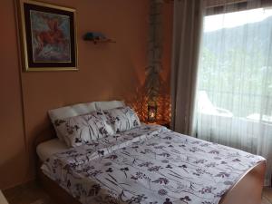 1 dormitorio con cama y ventana con colcha en Apartment Aki en Kotor