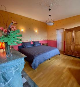 a bedroom with a bed in a room with a fireplace at Chambre Hôte Villa Sainte Barbe in Mirecourt