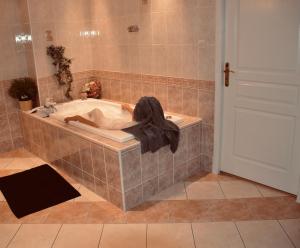 a bath tub with a person laying in it at Chambre Hôte Villa Sainte Barbe in Mirecourt +30 photos