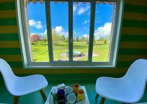 two chairs and a table in front of a window at Chambre Hôte Maison de Campagne Sainte Barbe in Mirecourt