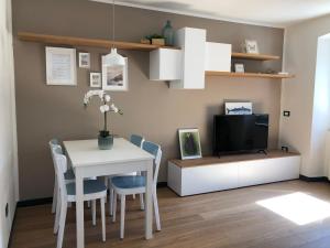 una sala da pranzo con tavolo bianco e TV di La Casa del Principe a Manarola