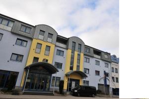 un bâtiment avec une voiture garée devant lui dans l'établissement AKZENT Hotel Stadt Schlüchtern ***S, à Schlüchtern