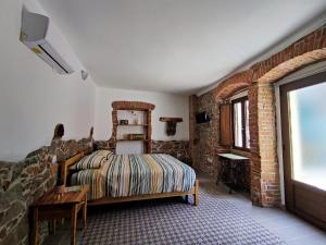 - une chambre avec un lit et un mur en briques dans l'établissement Sa Ferula, à Tortolì