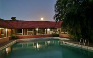 a swimming pool in front of a house at Hotel El Bramadero in Liberia