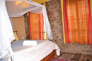 ein kleines Schlafzimmer mit einem Bett mit Baldachin in der Unterkunft Mondi Lodge Kisoro in Kisoro