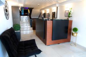 a lobby with a counter and a chair and stairs at Miami Beach Hotel Tel Aviv in Tel Aviv