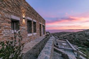 a brick building with a sunset in the background at Tinos Dove Suites in Triandáros