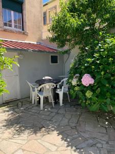 patio ze stołem, krzesłami i kwiatami w obiekcie Hostel Brazuca w Porto