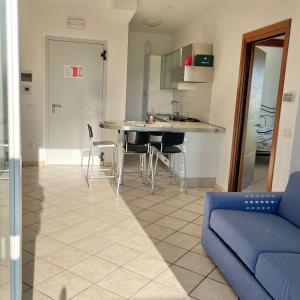 a living room with a blue couch and a kitchen at Oltre l’orizzonte in Fermo +5 photos