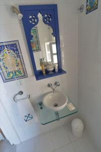 ein Bad mit einem Waschbecken und einem Spiegel in der Unterkunft The Admiral's House Kastellorizo in Megisti