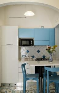 una cucina con armadi blu e 2 sedie blu di La Rosa dei Venti - Libeccio a Maiori