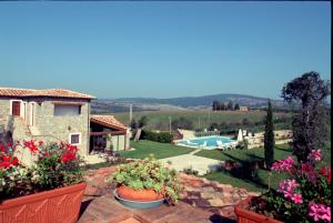 a house with a garden and a swimming pool at Relais Le Ginestre in Saturnia