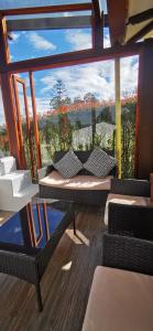 Zimmer mit einem großen Fenster mit einem Tisch und Stühlen in der Unterkunft Villa Monica HR in Villa de Leyva
