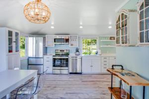 a kitchen with white cabinets and a wooden floor at Seaview Cottage in Blaine