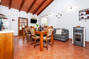 cocina y sala de estar con mesa de madera y sillas en House Ulika, en Bale