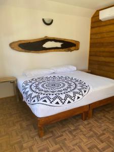 a bed with a black and white comforter in a room at Hotel Aruma Ha in Holbox Island