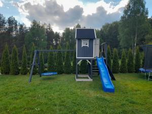 a playground with a house and a slide at Dom na Warmii in Barczewo