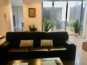 a black couch in a living room with plants at Casa de pueblo amplia in Sa Pobla