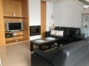 a living room with a black couch and a tv at Casa de pueblo amplia in Sa Pobla