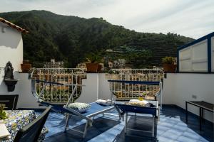 a balcony with chairs and a view of a mountain at La Rosa dei Venti - Levante in Maiori