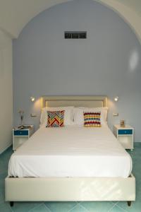 a white bed with two pillows on top of it at La Rosa dei Venti - Grecale in Maiori