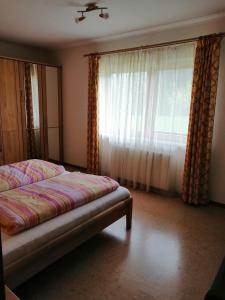 ein Schlafzimmer mit einem Bett und einem großen Fenster in der Unterkunft Large cozy apartment Grubweg 130 qm in Sankt Martin am Tennengebirge