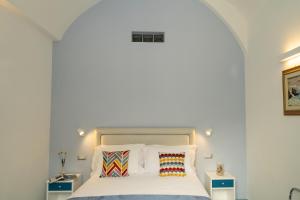 a bedroom with a large bed with white sheets and pillows at La Rosa dei Venti - Grecale in Maiori