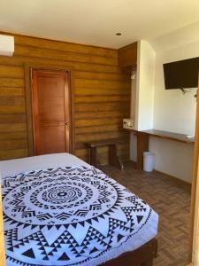 1 dormitorio con 1 cama con edredón blanco y negro en Hotel Aruma Ha en Holbox Island