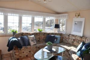 a living room with a couch and a glass table at Saltviks Stugby & Camping in Grebbestad